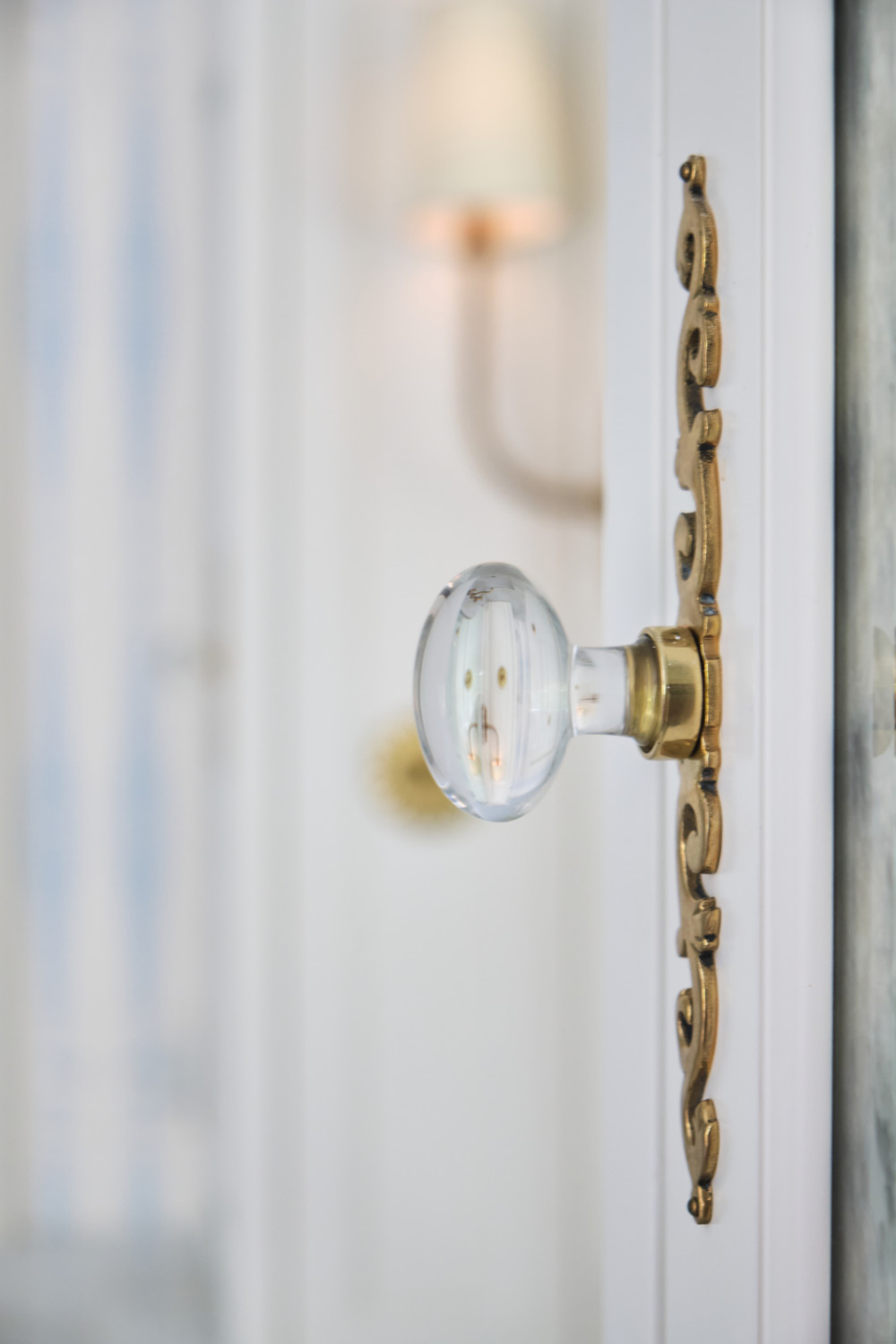 a glass knob with brass detail in the primary bathroom