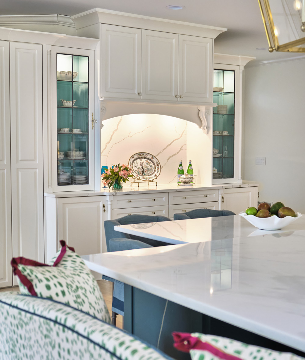 the built in cabinetry connects the colors of the bench and pillows at the kitchen island