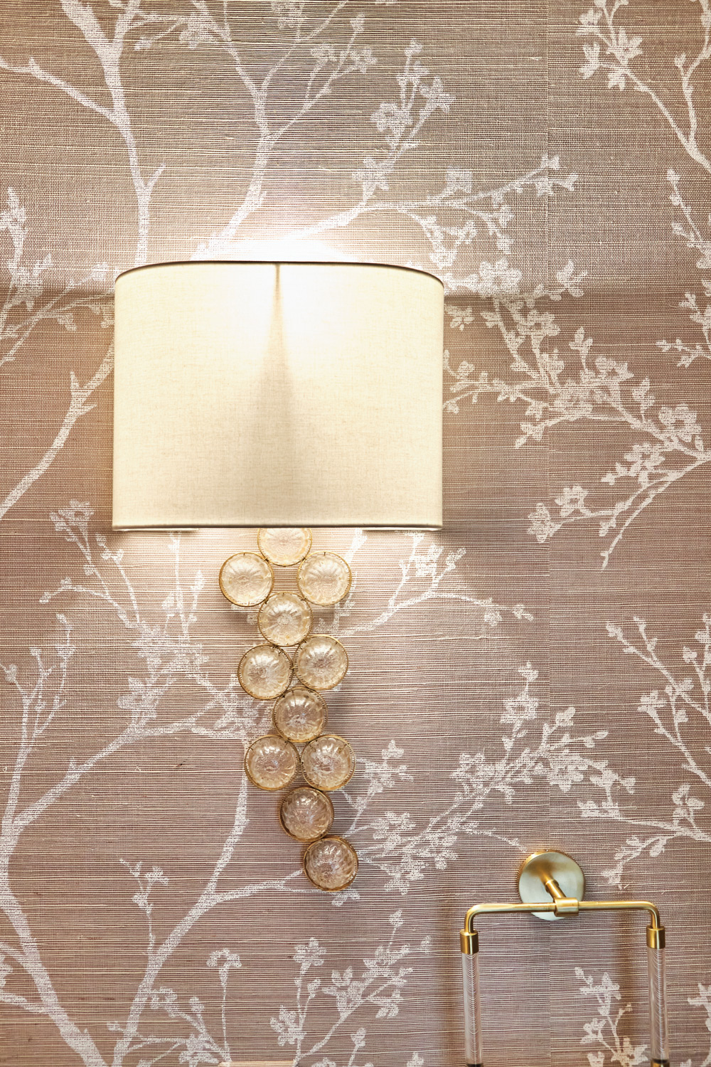 the gold and glass sconce in the bathroom