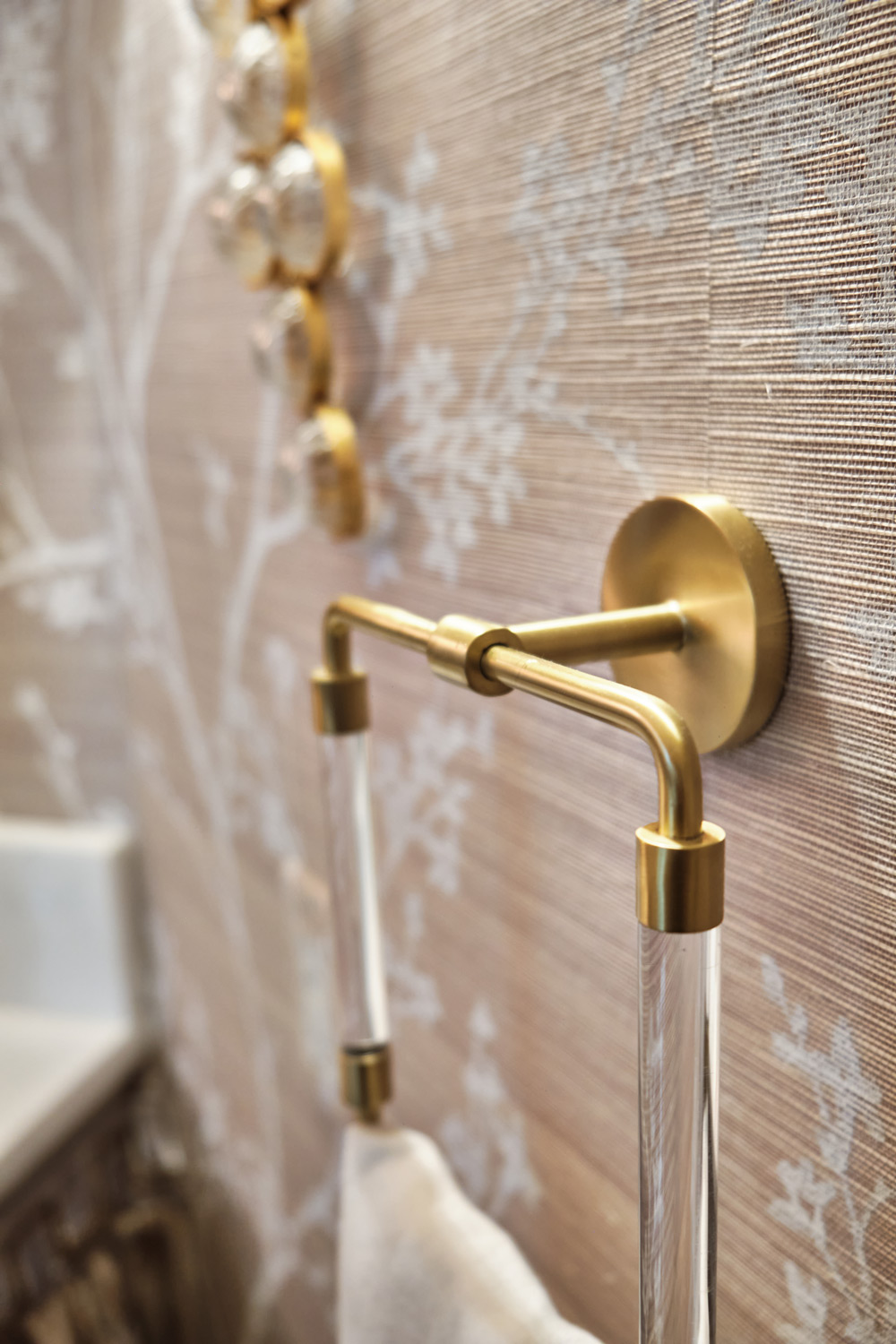 gold and clear acrylic towel holders match the sconce in the bathroom
