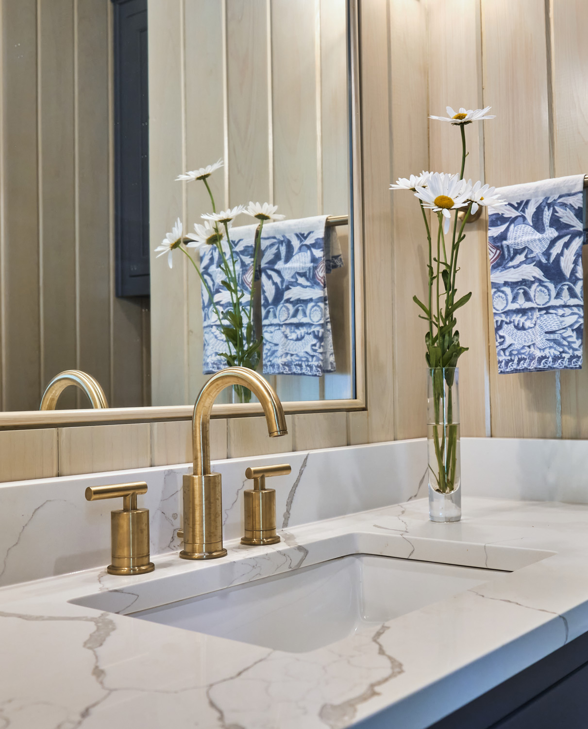 updated quartz counters and gold faucet in the pool house bathroom