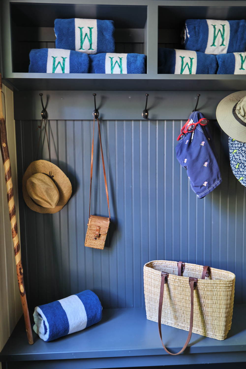 a blue mud room with cabinetry detail matches the rest of the pool house