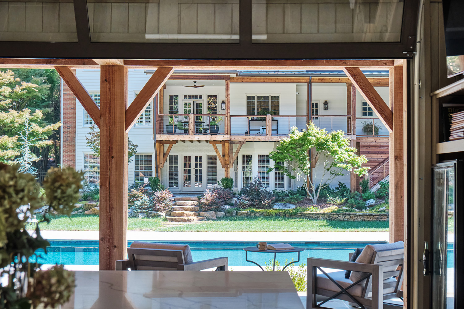 wood beams in the pool house tie into wood beams on the main house's design